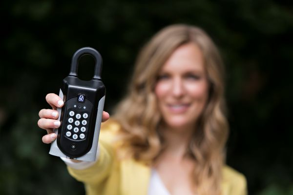 A woman holding a SentriGuard commercially graded key safe